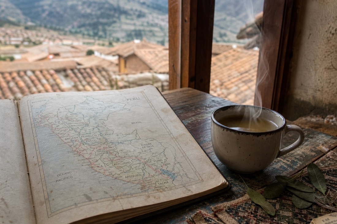 Open travel journal with a hand-drawn Peru route map beside a cup of coca tea