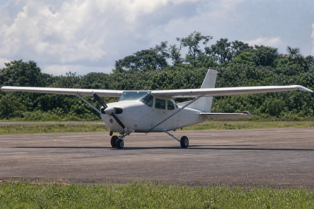 Small propeller plane on the tarmac of a regional Amazon airport in heavy afternoon light